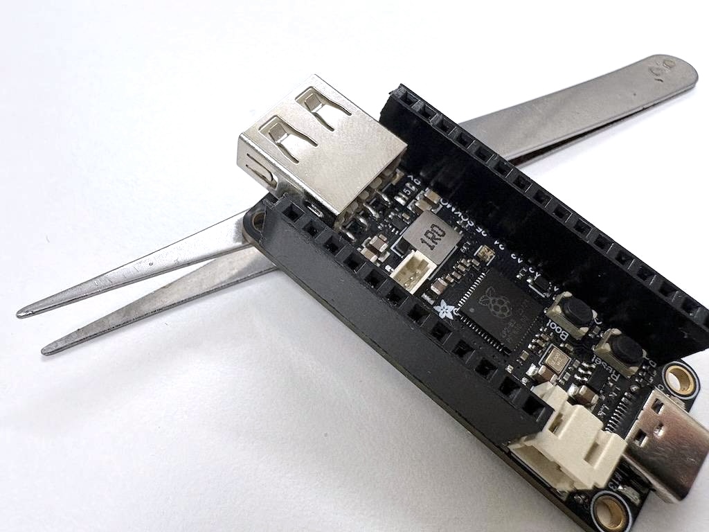 Adafruit Feather RP2040 with USB Type A Host, with headers on top.